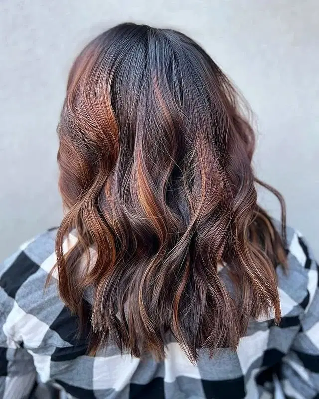 Medium-length wavy hair with copper and auburn balayage highlights
