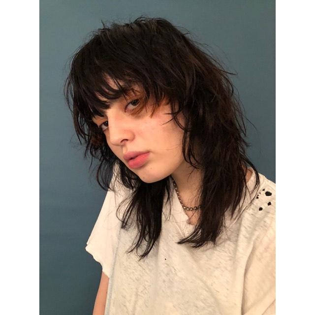 A modern shag haircut with choppy, textured layers and fringe bangs, embodying a lived-in, carefree cool.