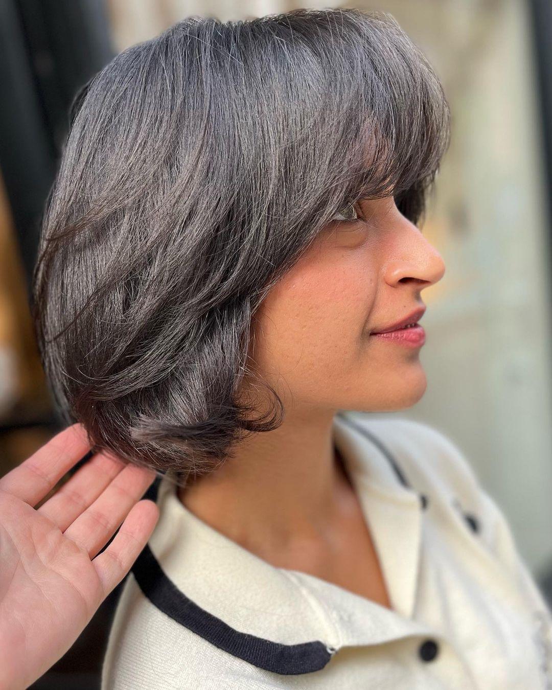 A stylish and modern short bob with a sophisticated blend of silver and grey. The straight hair features a side-swept fringe and layered sections for added movement and depth. 3