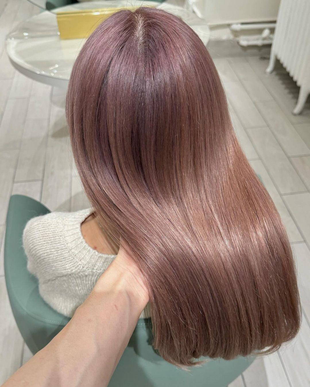 Smooth, straight medium-length hair in a sleek and glossy rose gold shade, featuring a soft pink hue. The hairstyle includes a side-part which allows the hair to drape naturally over the shoulders. 2