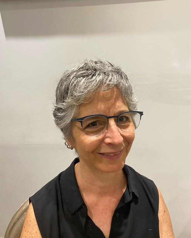 A short, layered silver pixie crop with wispy layers for a modern look.