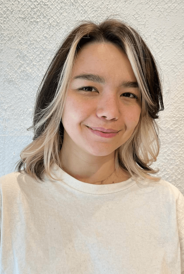 Medium-length wavy hairstyle with black as the base color and platinum blonde face-framing highlights. Features natural waves and soft layers for added dimension. 2