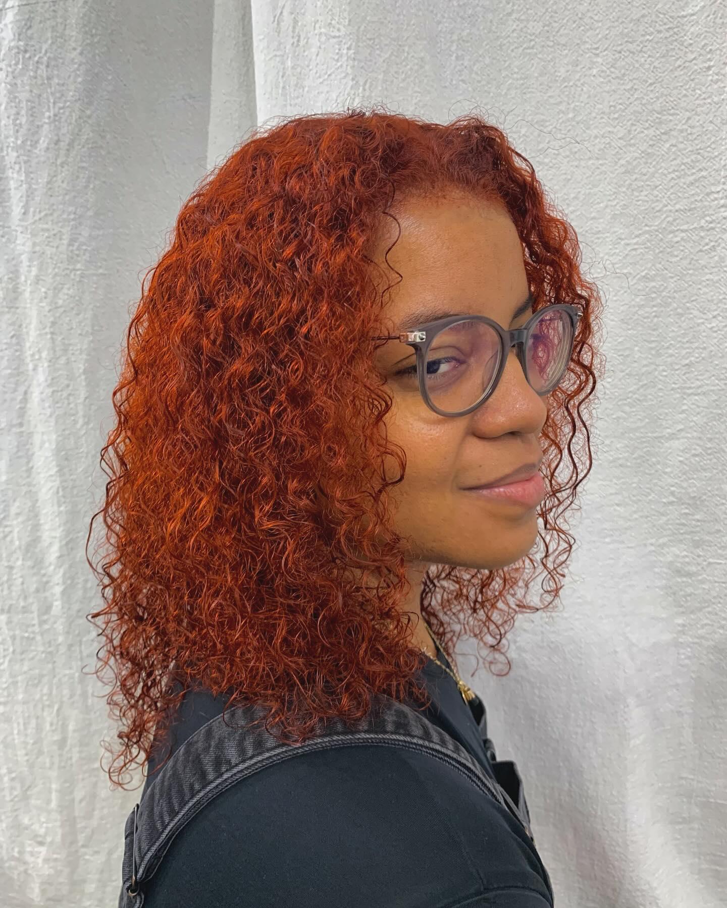 Medium-length curly hair in bold red and copper, with defined curls and voluminous texture. 1