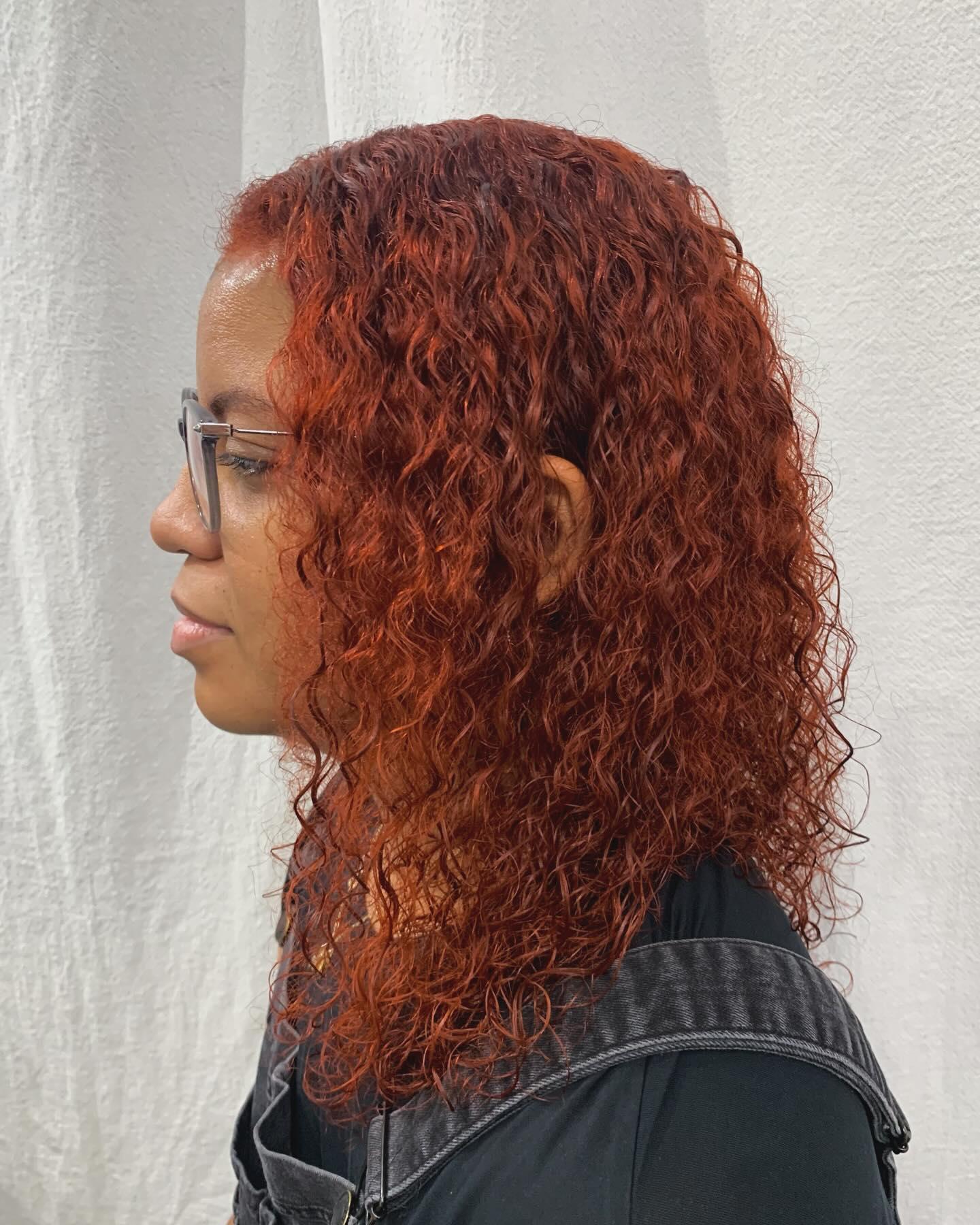 Medium-length curly hair in bold red and copper, with defined curls and voluminous texture. 2