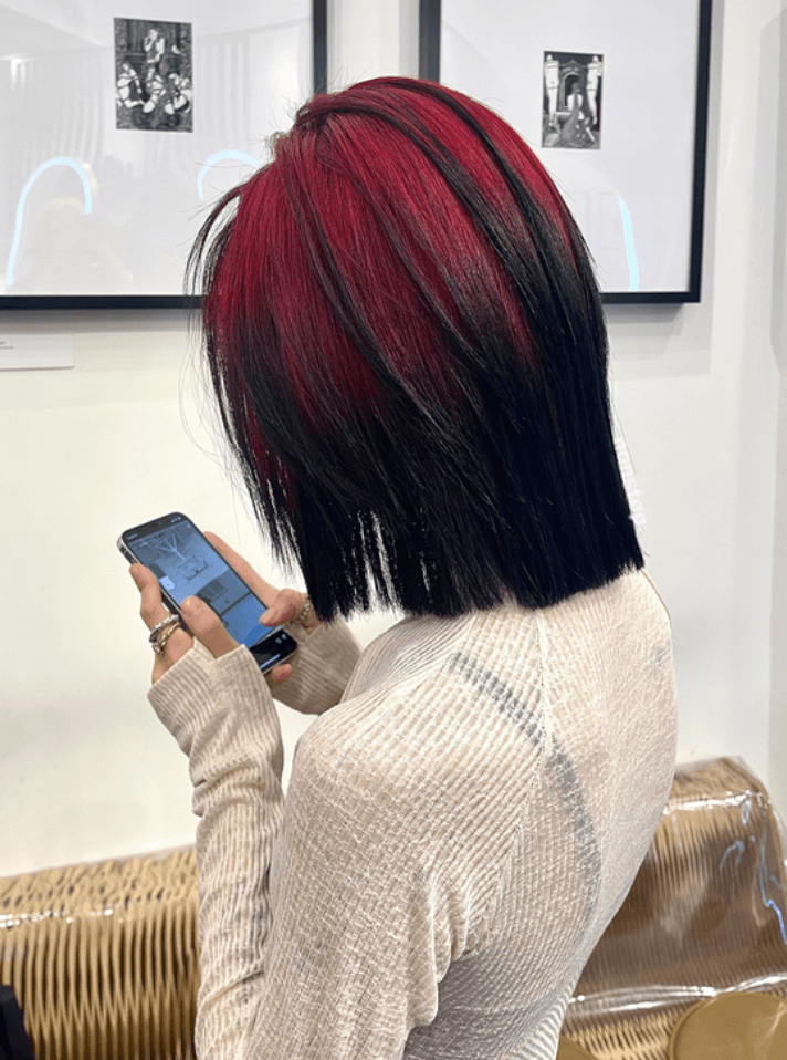 A medium-length straight bob with vibrant crimson red hues on the top layers, transitioning into deep black.