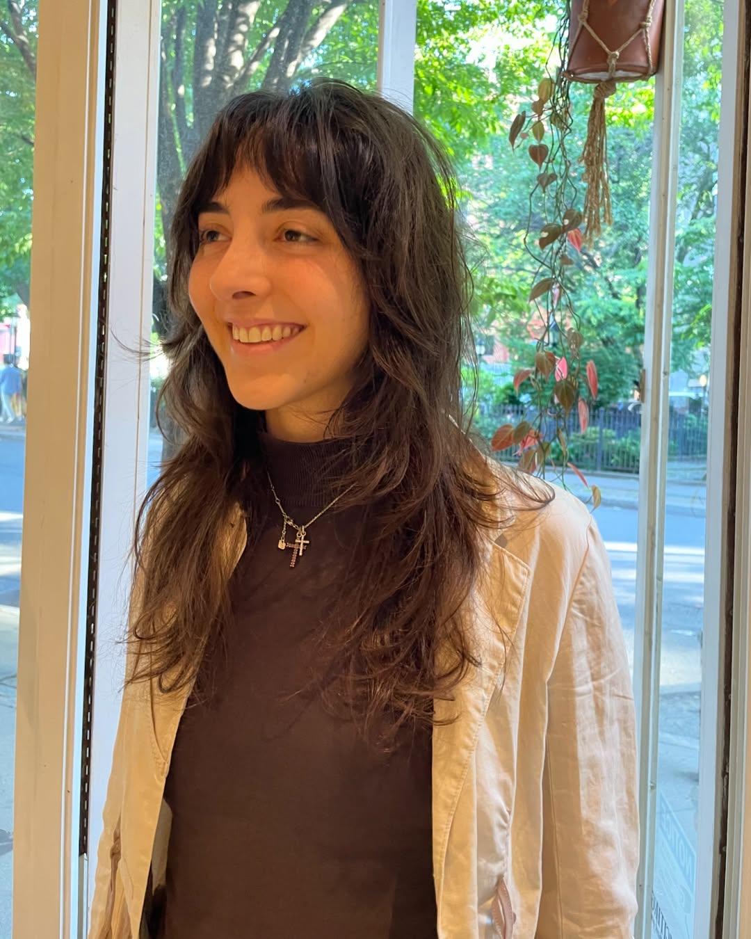 A modern shag haircut with choppy layers and trendy curtain bangs, embodying personalized style.