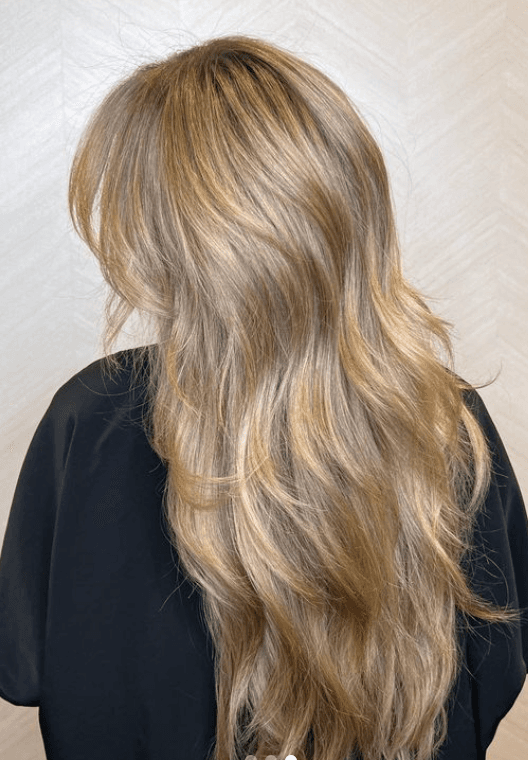 Long, wavy blonde hair with golden highlights, featuring a natural, layered flow and soft, loose waves.

Color by @simabeautynyc
Cut and style by @juliamannino_hair
 1