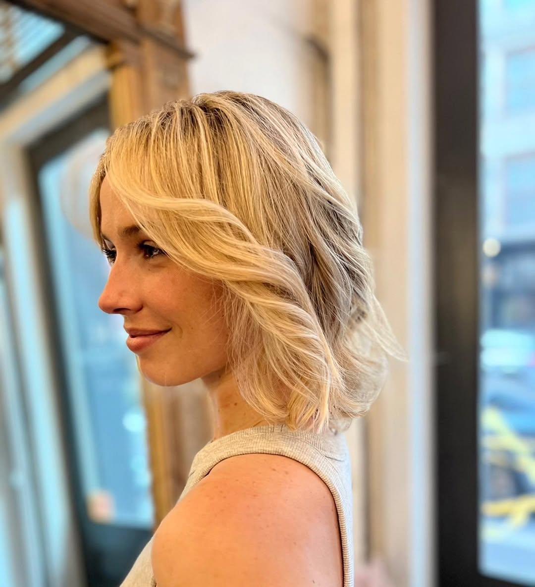 Medium-length wavy blonde hair with a layered cut, featuring soft waves and a side part with subtle highlights.

Color by Kaori. Cut by Taka. Style by Hazuki 1