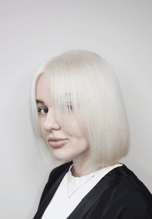 Trendy blunt bob haircut with short, icy blonde baby bangs.