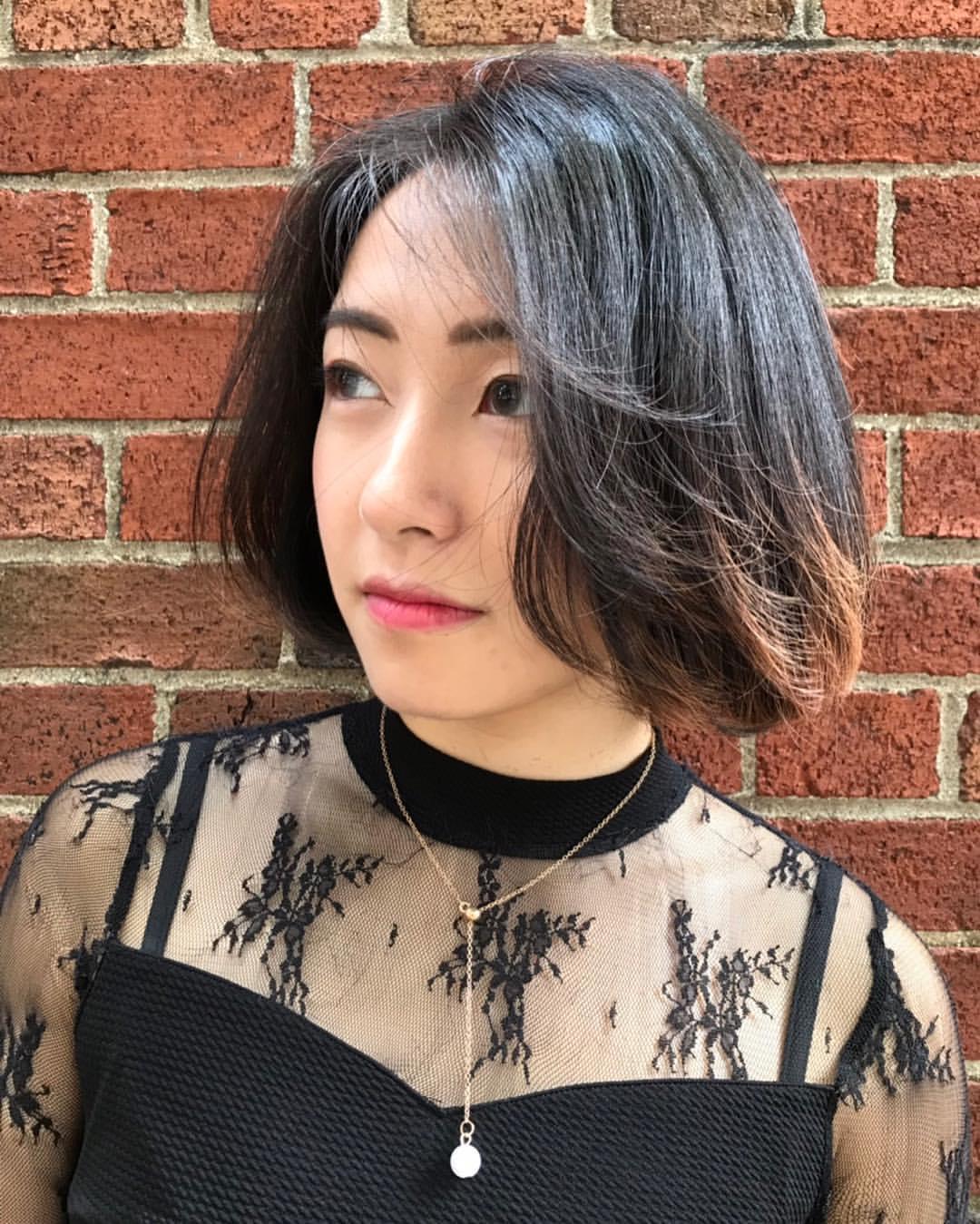 A sleek, medium-length, straight bob with an asymmetrical, side-parted design, featuring a deep, rich black color and a smooth, silky texture. 2