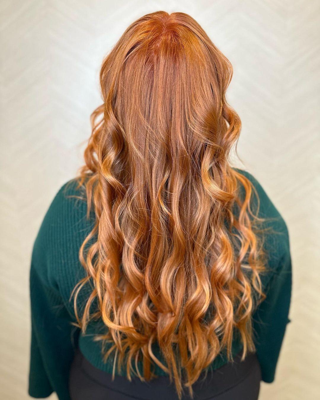 Very long, copper-colored hair with voluminous waves and loose curls, featuring layered cuts and golden highlights for added dimension.

Color by @simabeautynyc
Cut and style by @juliamannino_hair
 1
