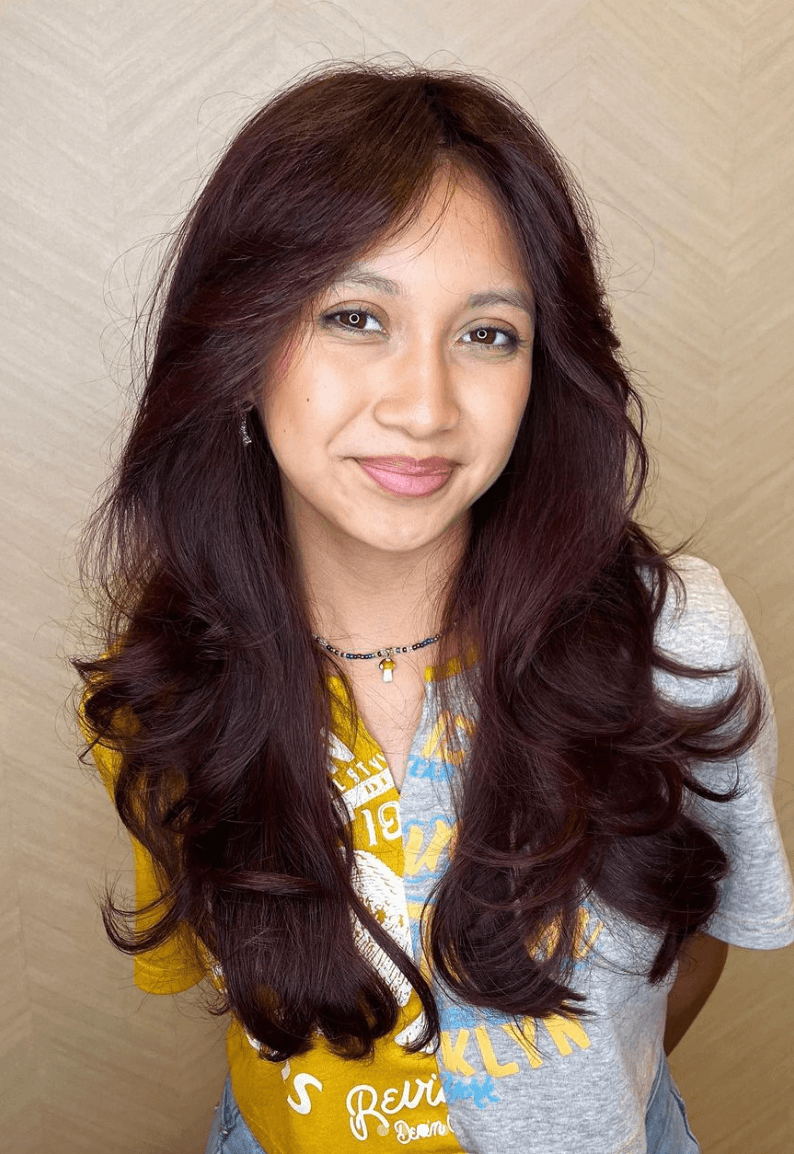 Long, wavy, layered hairstyle in rich burgundy color, with a side part and face-framing layers.

Cut and style by @juliamannino_hair
 1