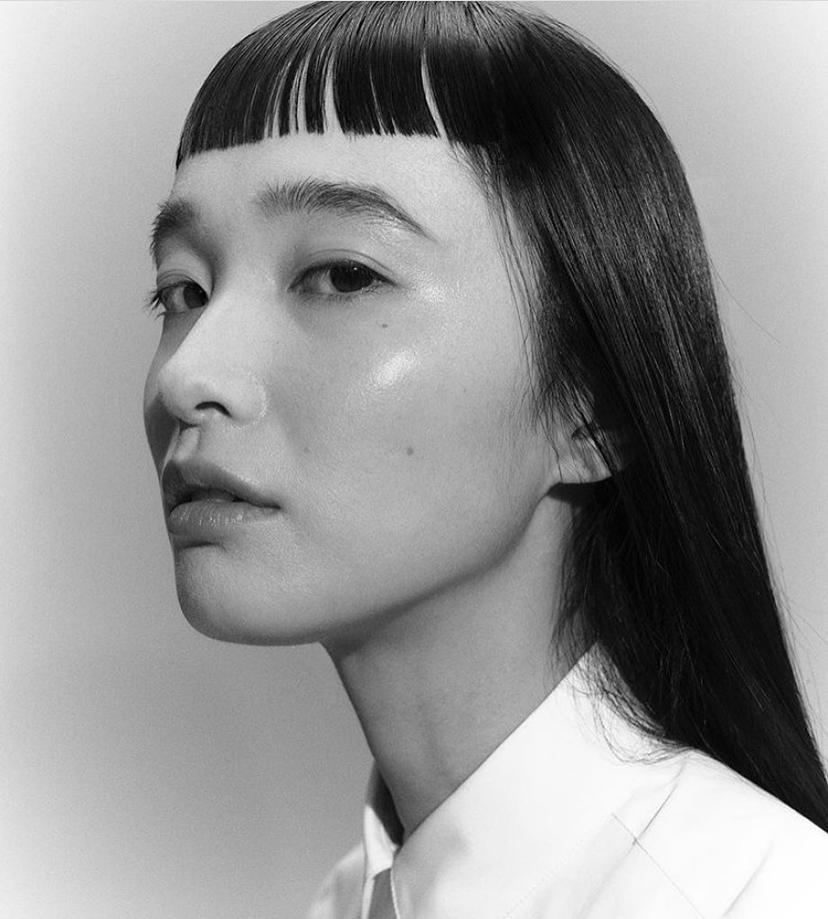Sleek, straight jet-black hair with precision-cut blunt Japanese bangs.