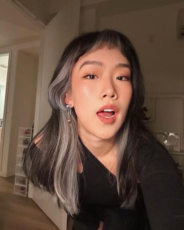 Medium-length straight hair with ash silver peekaboo highlights and microbangs.