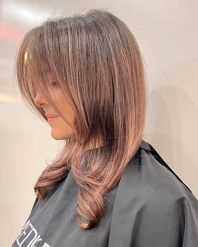 Bronzed Layered Bob with soft face-framing layers and curtain bangs.