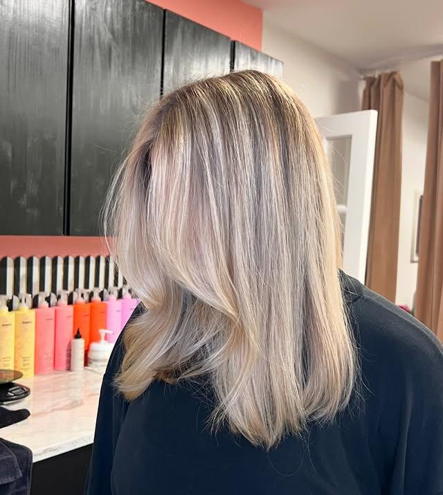 Icy blonde balayage with face-framing layers on straight, medium-length hair