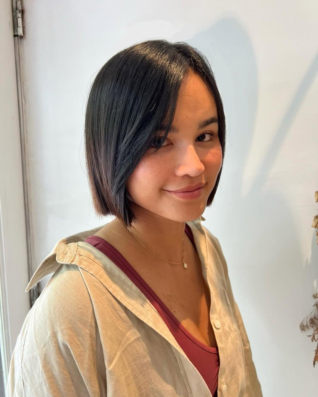 Sleek blunt bob haircut sitting at chin length, perfectly framing the jawline.