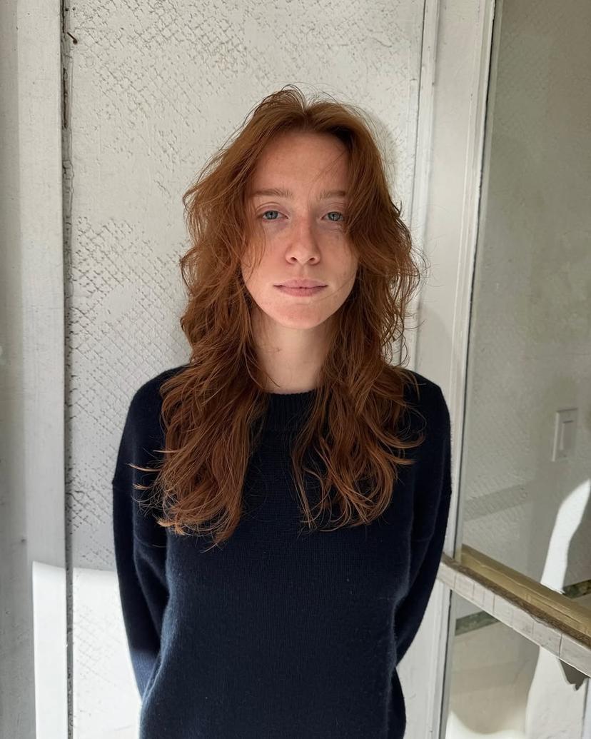 Long, wavy copper and auburn hair with natural texture and soft, face-framing layers.