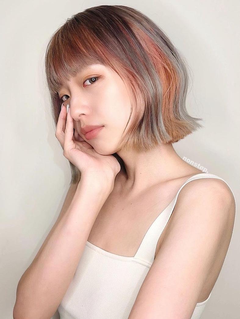 A stylish short bob featuring straight textures with straight bangs, two-toned copper and grey hues blending into black roots, and subtly angled ends framing the face. 🌄 Sunset girl by HIRO 1