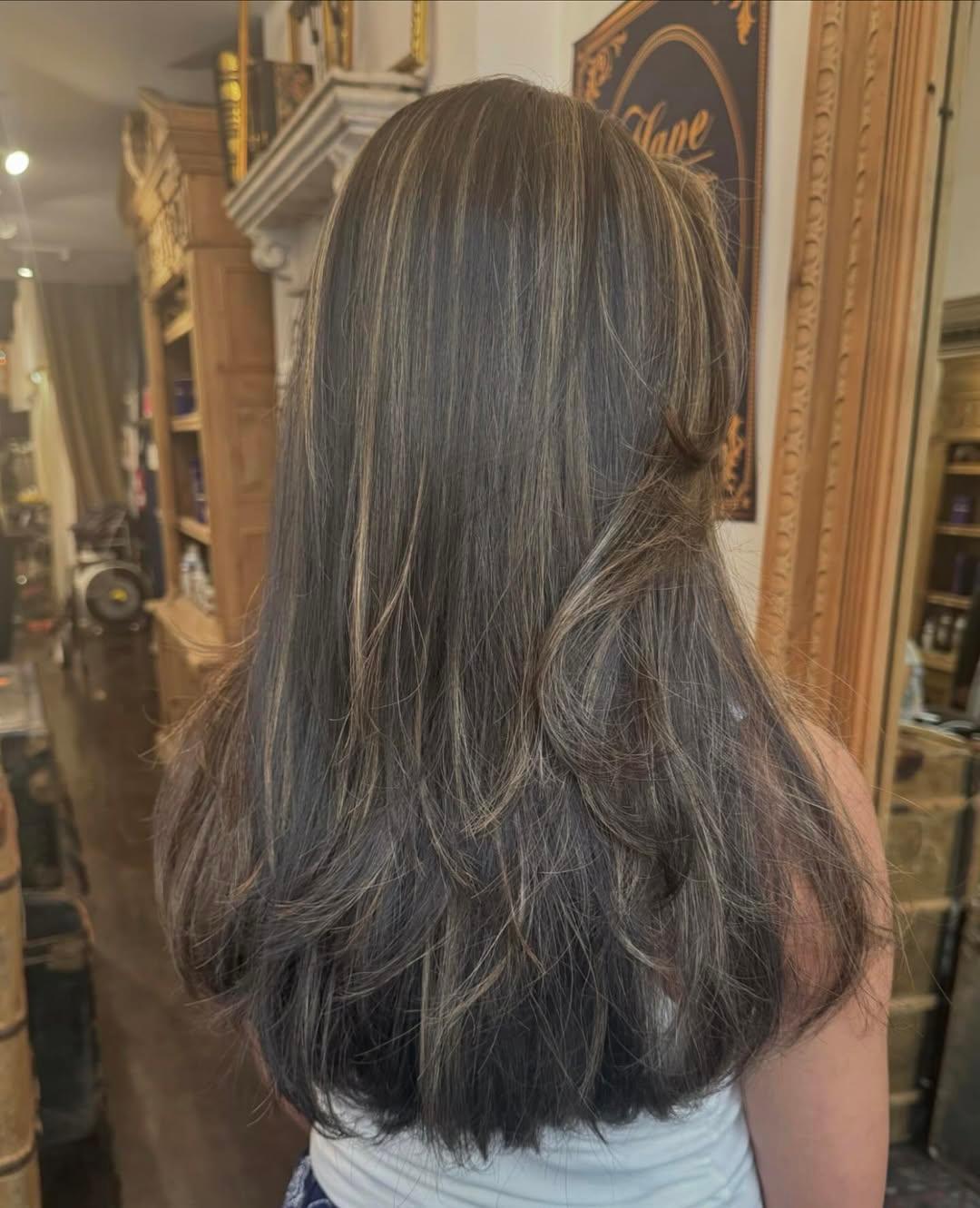 Long, straight, dark brown hair with ash blonde highlights, layered for volume with a sleek finish. 1