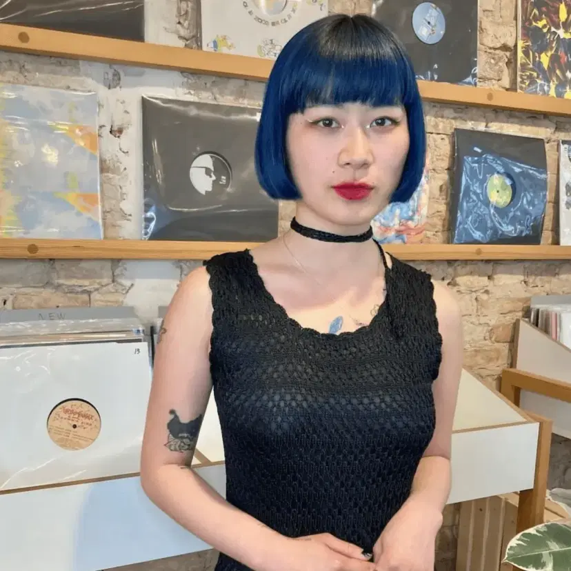 A bold and edgy short bob haircut in electric blue with blunt bangs.