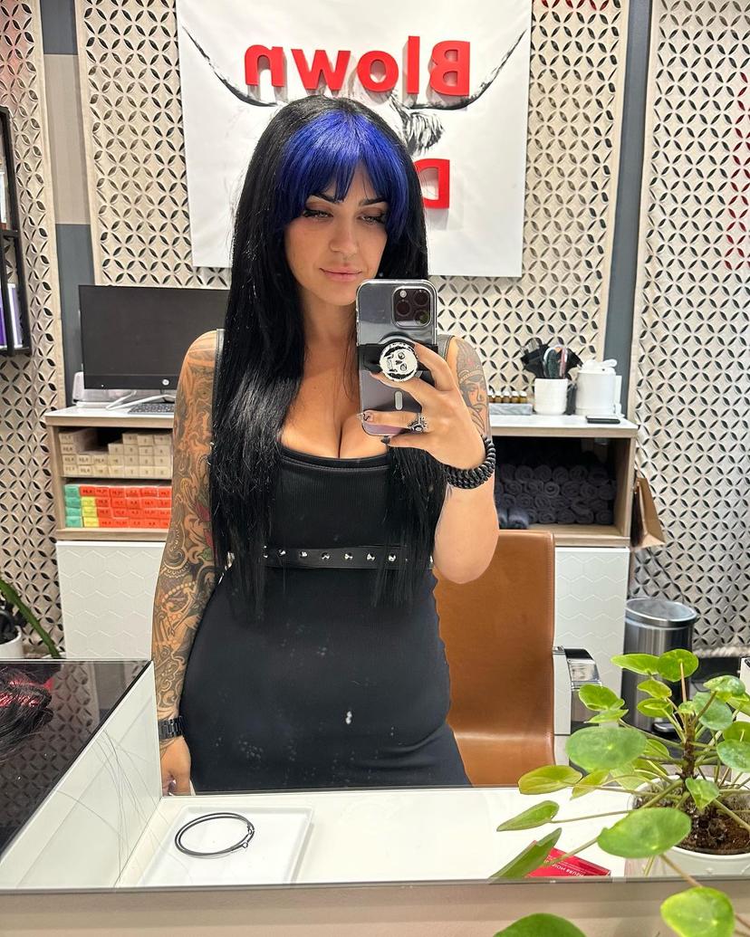 Long straight black hair with blunt electric blue bangs for an edgy scene look.