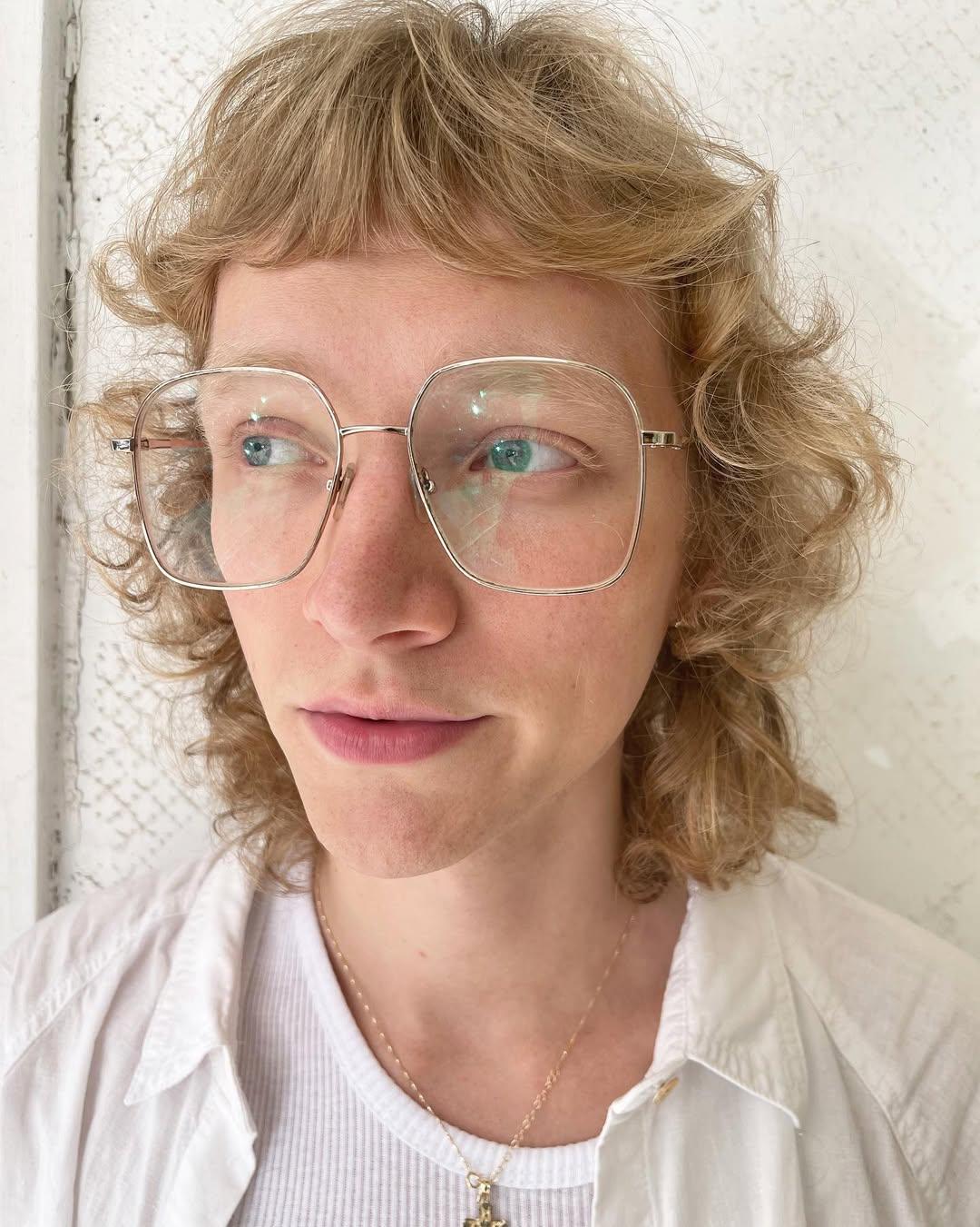 Medium-length, honey gold curls with a soft fringe and layered for volume, creating a retro and casual elegant look. 1