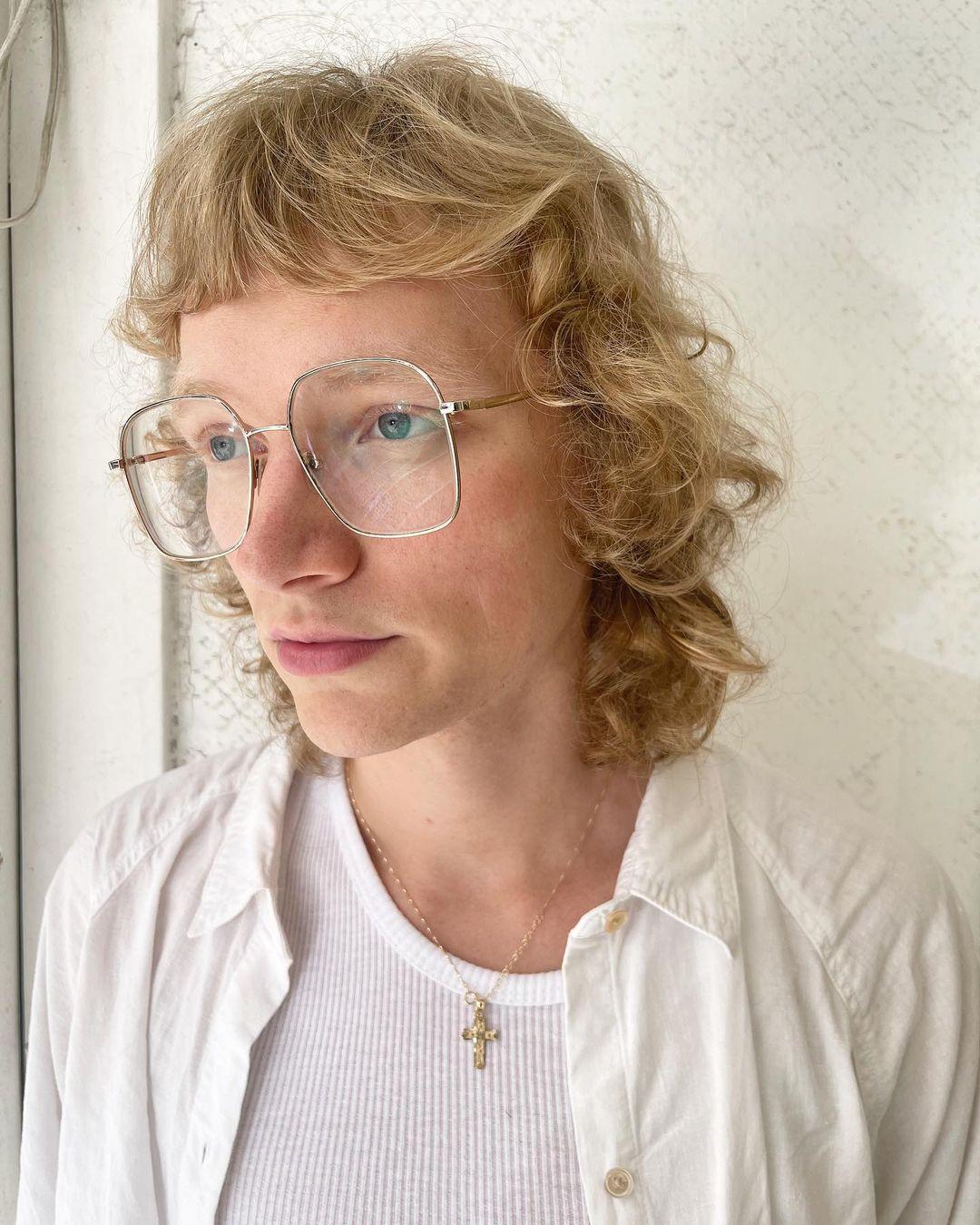 Medium-length, honey gold curls with a soft fringe and layered for volume, creating a retro and casual elegant look. 2