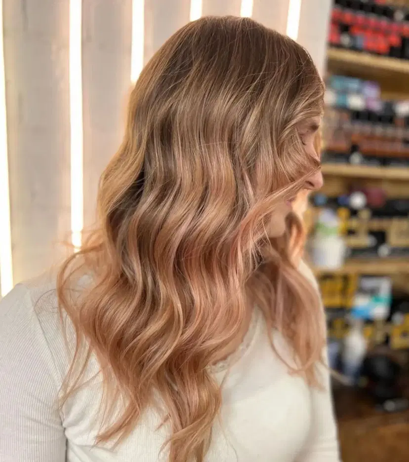 Long, wavy hair with golden blonde and honey brown balayage, featuring loose beach waves
