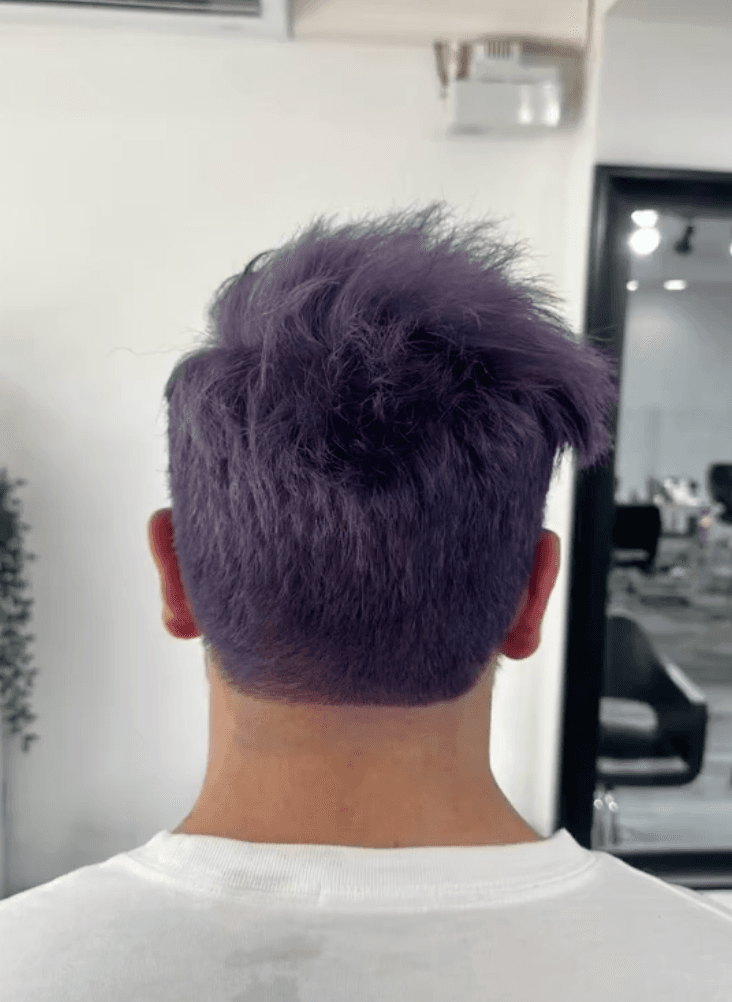 A vibrant short hairstyle with a purple color. The hair is straight and has a textured top, styled upward with a spiky effect, combined with neat side fades. 3