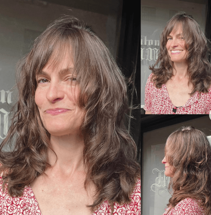 Woman with effortless layered waves and face-framing curtain bangs