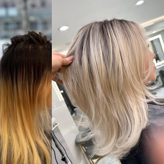 Icy blonde layered lob with dark roots for a trendy, dimensional look