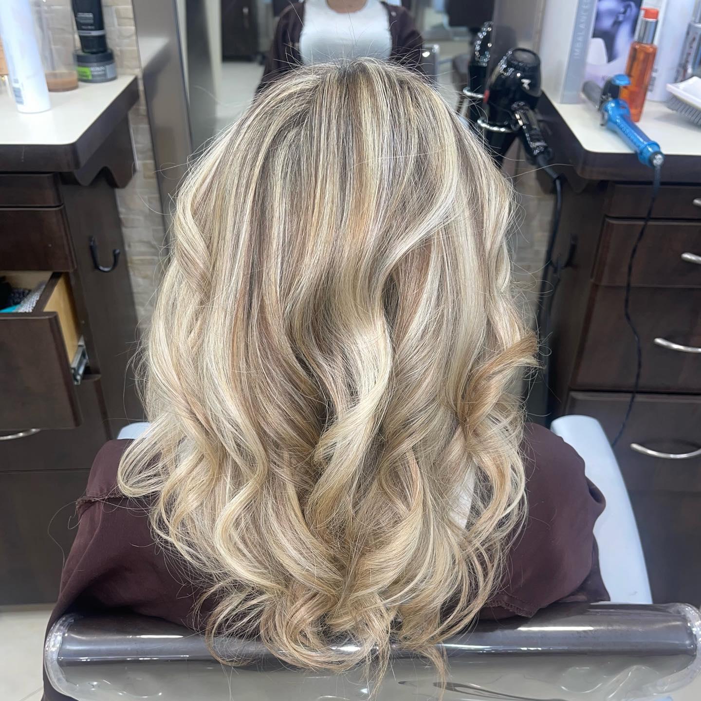 Long, wavy hair with a stunning blonde balayage, creating a dimensional and beachy look.