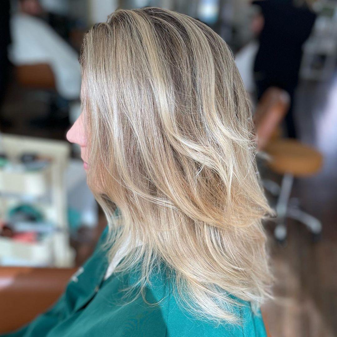 Long wavy hair with subtle gray blending highlights for a natural ombre effect.