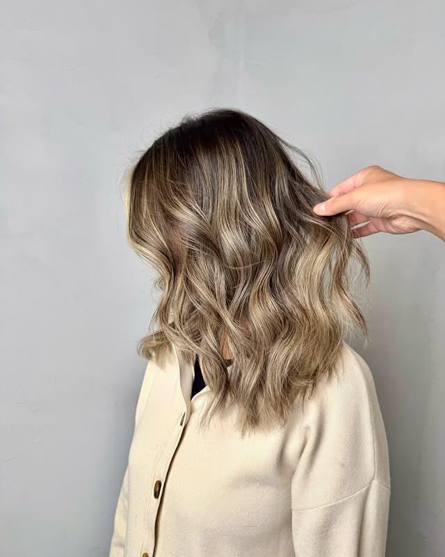 A trendy medium-length lob with bronde balayage and effortless beach waves.