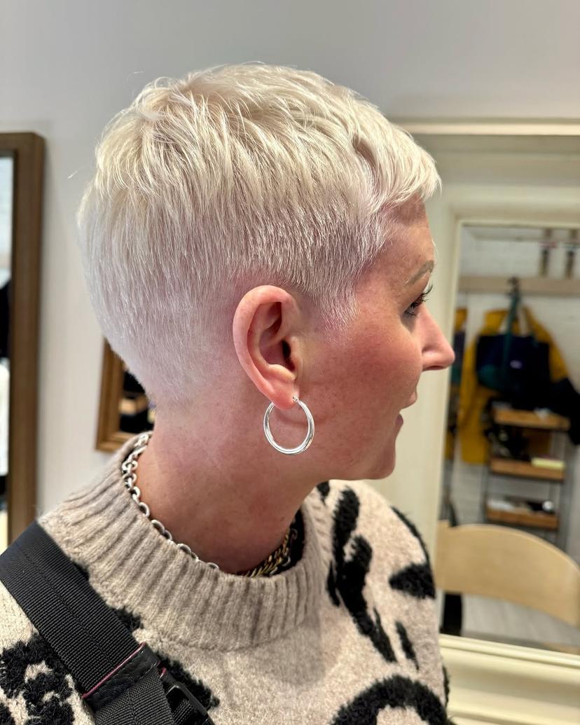 A textured platinum blonde pixie cut, perfect for a modern and edgy look.