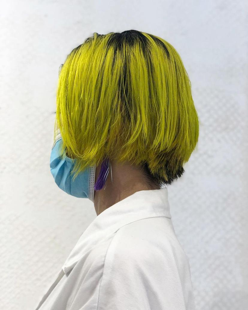 Striking layered bob with vibrant yellow contrasting boldly against dark black roots