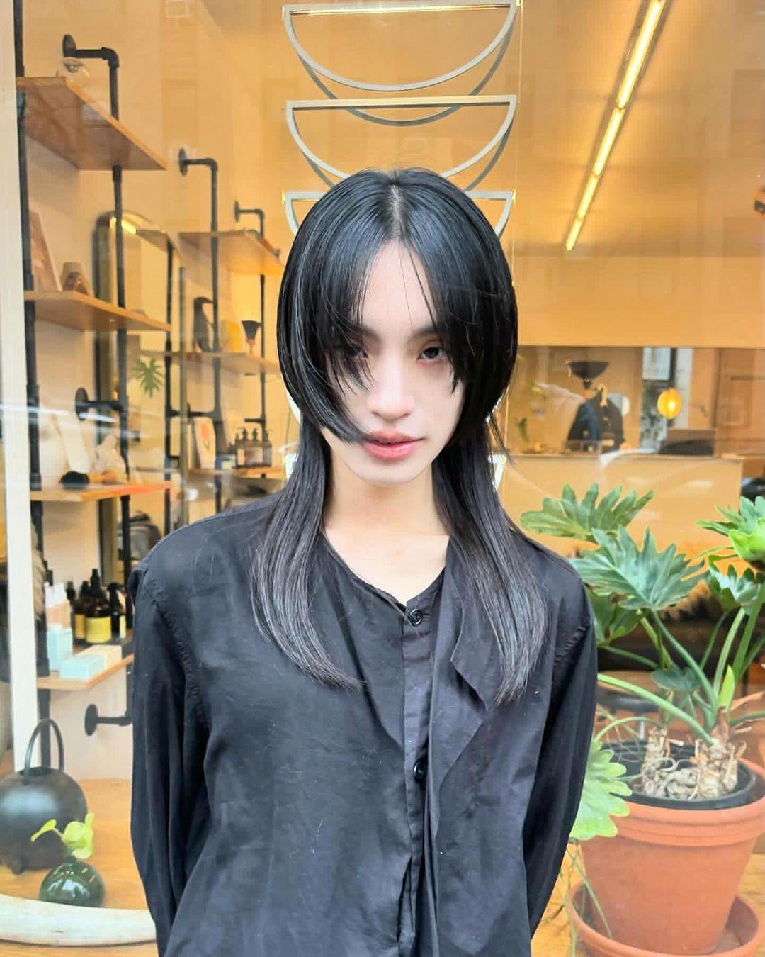 Jet black, straight hair with medium length and layered bangs, featuring feathered layers and a face-framing, edgy look. 3