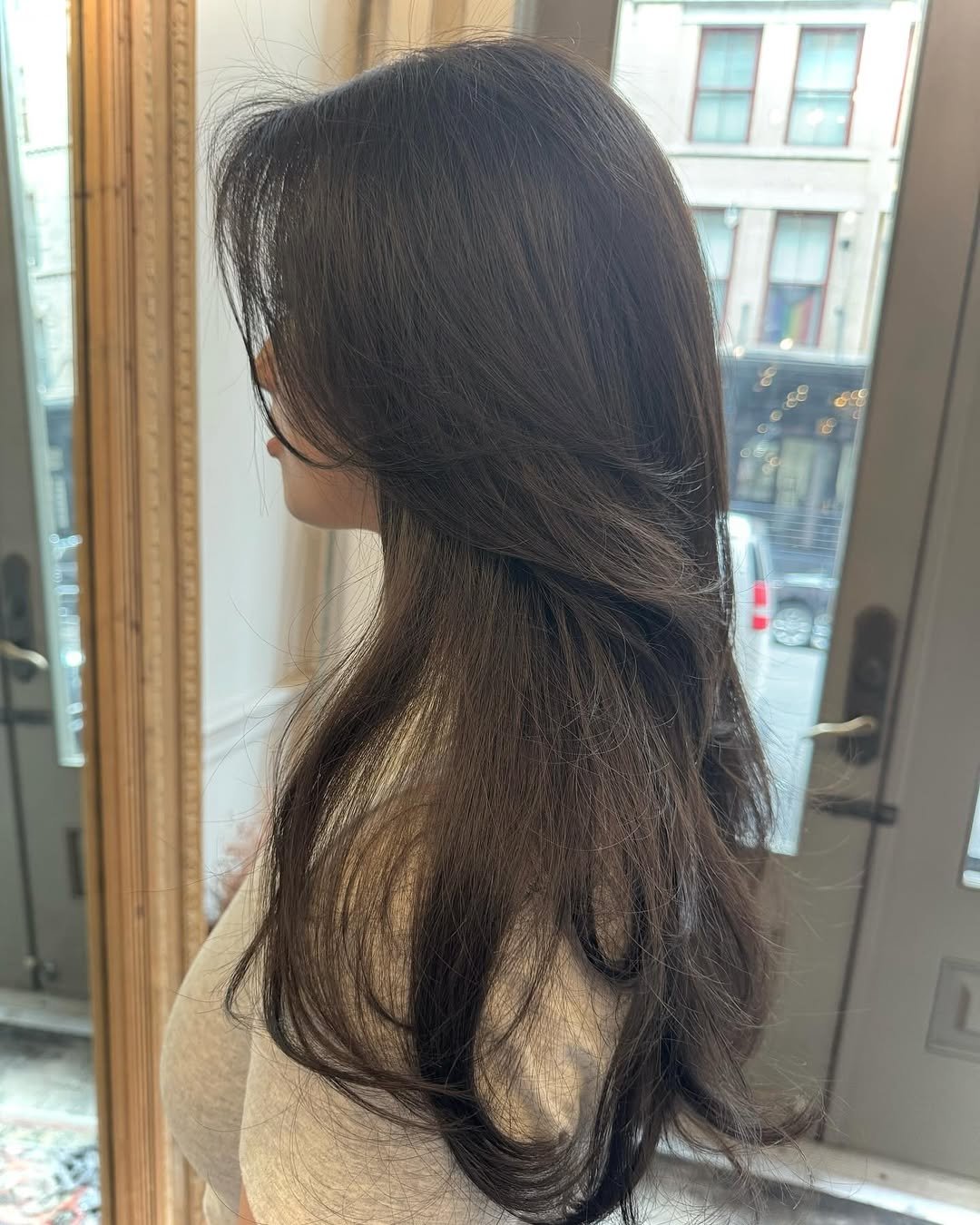 Long, layered, dark brown wavy hair with voluminous face-framing strands. 2