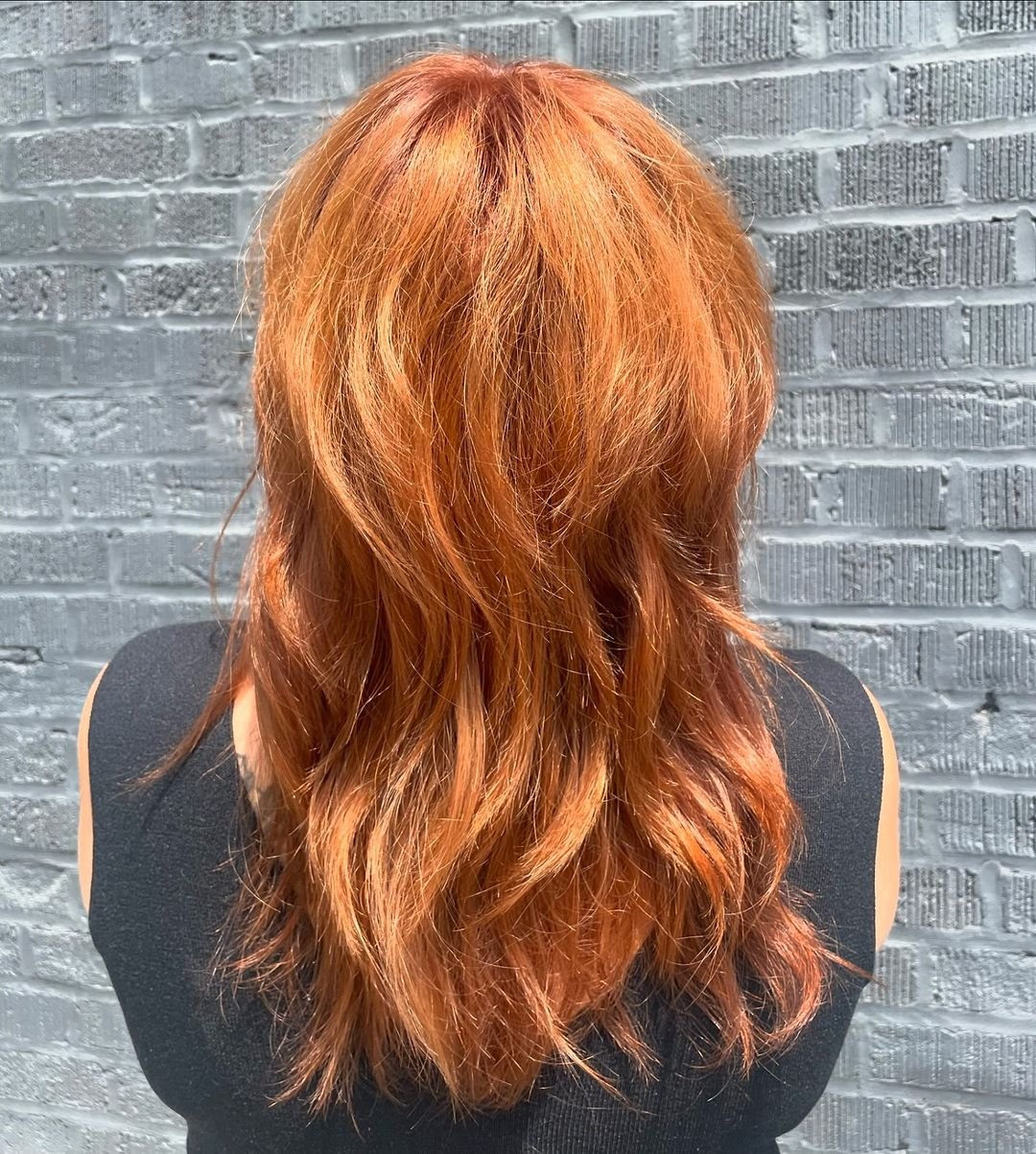 Medium-length cut with soft waves and a textured fringe, featuring a vibrant copper color. 2